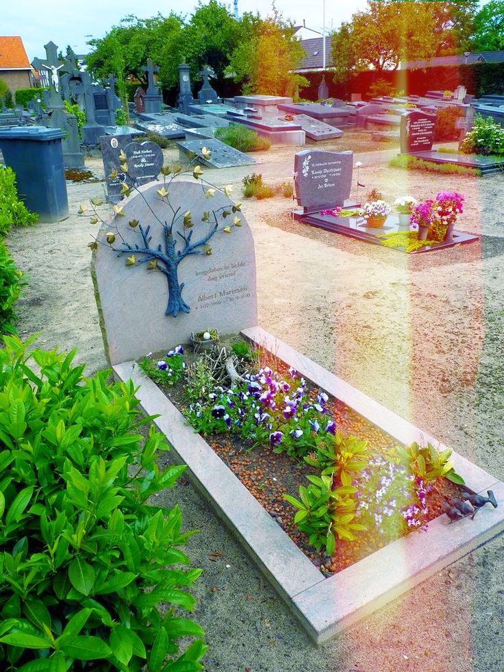 a grave yard with flowers and trees in it