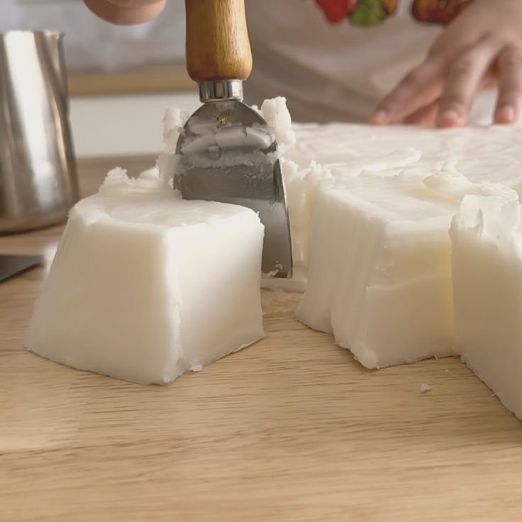 a person is cutting cheese with a knife