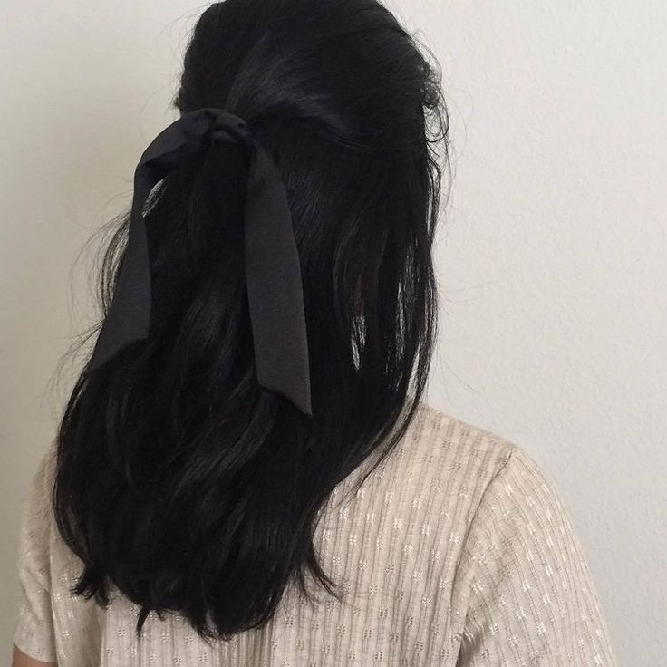 the back of a woman's head wearing a black bow