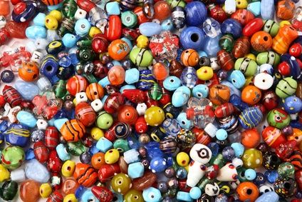 many different colored glass beads are stacked together