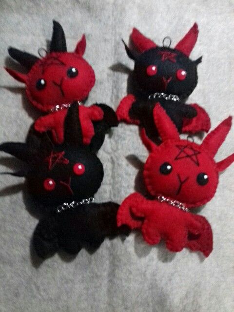 four red and black stuffed animals on a white blanket