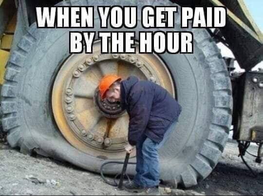 a man working on a tire with the caption when you get paid by the hour