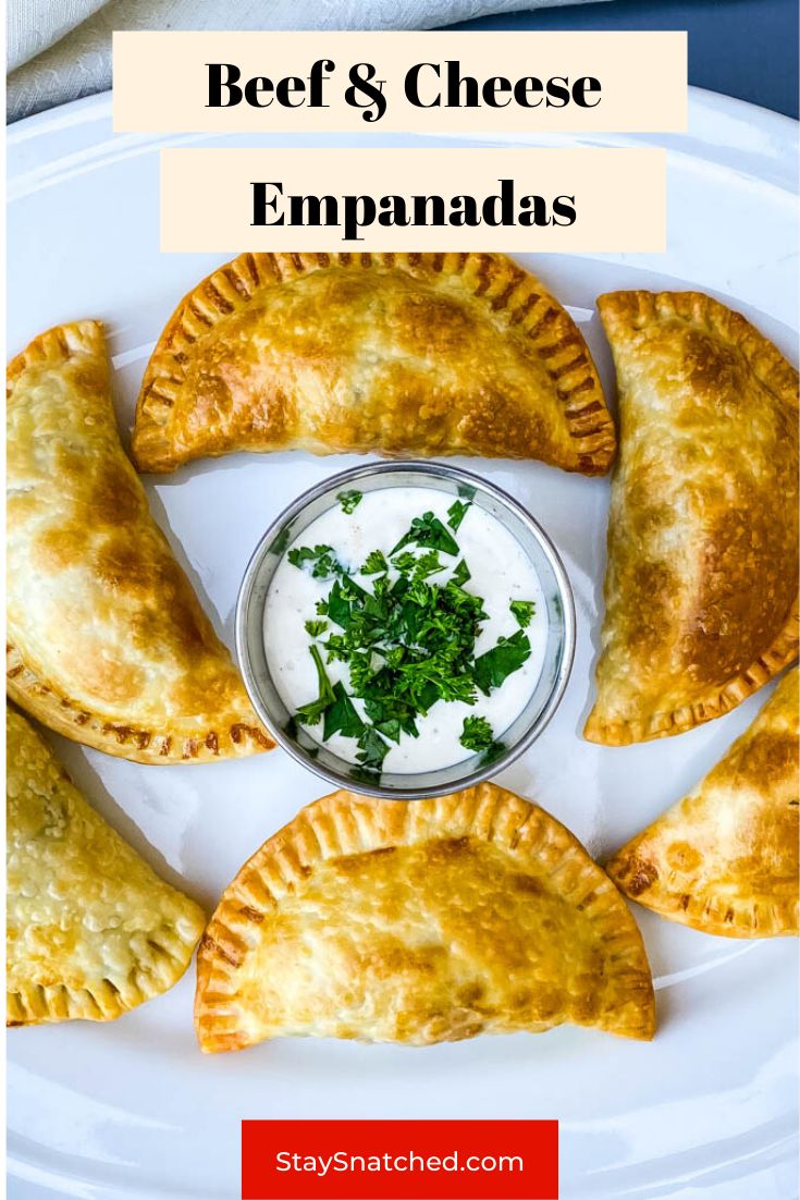 beef and cheese empanadas on a white plate with ranch dip in the middle