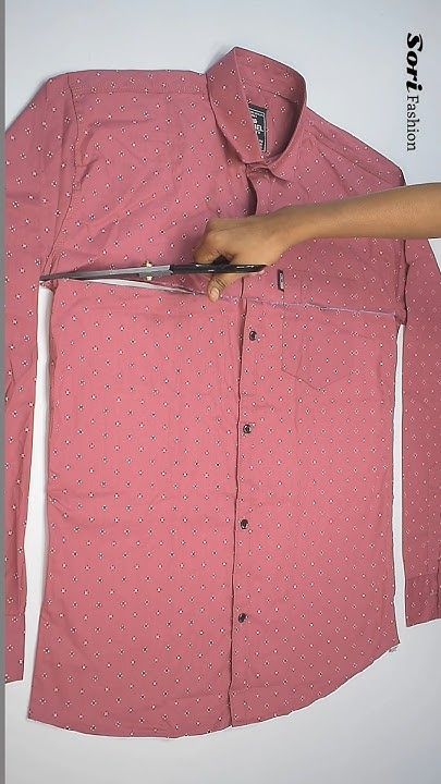 a person is cutting through a pink shirt with a pair of scissor blades