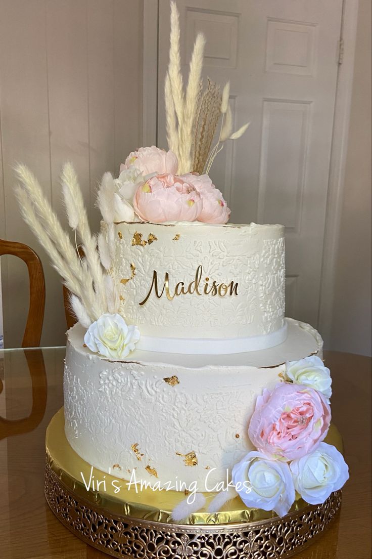 a wedding cake with flowers and feathers on top