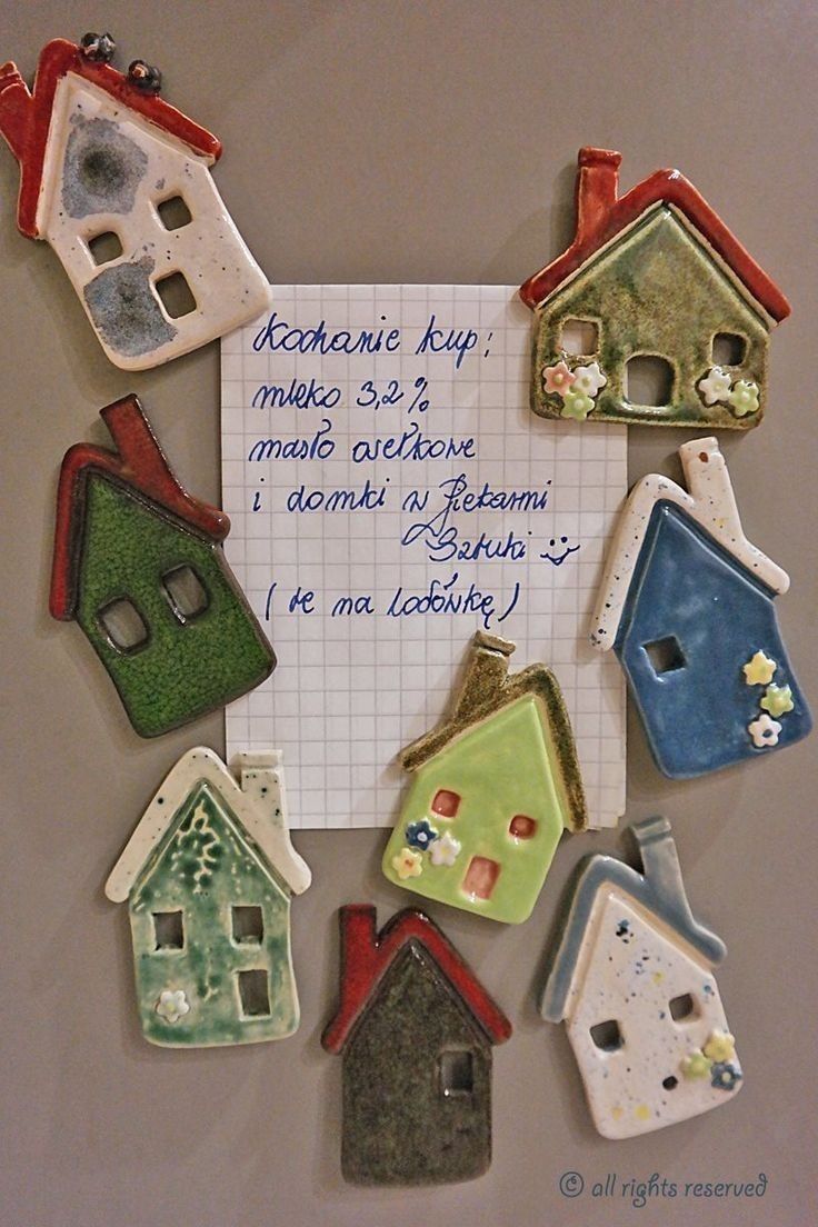 there are many small ceramic houses on the sheet of paper that is attached to the wall