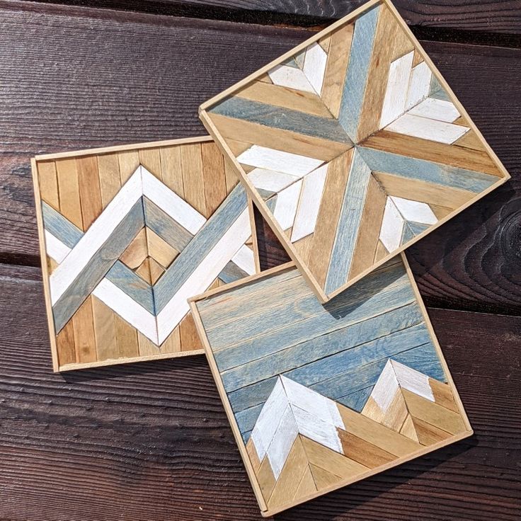 three wooden coasters with arrows painted on them sitting on top of a wooden table