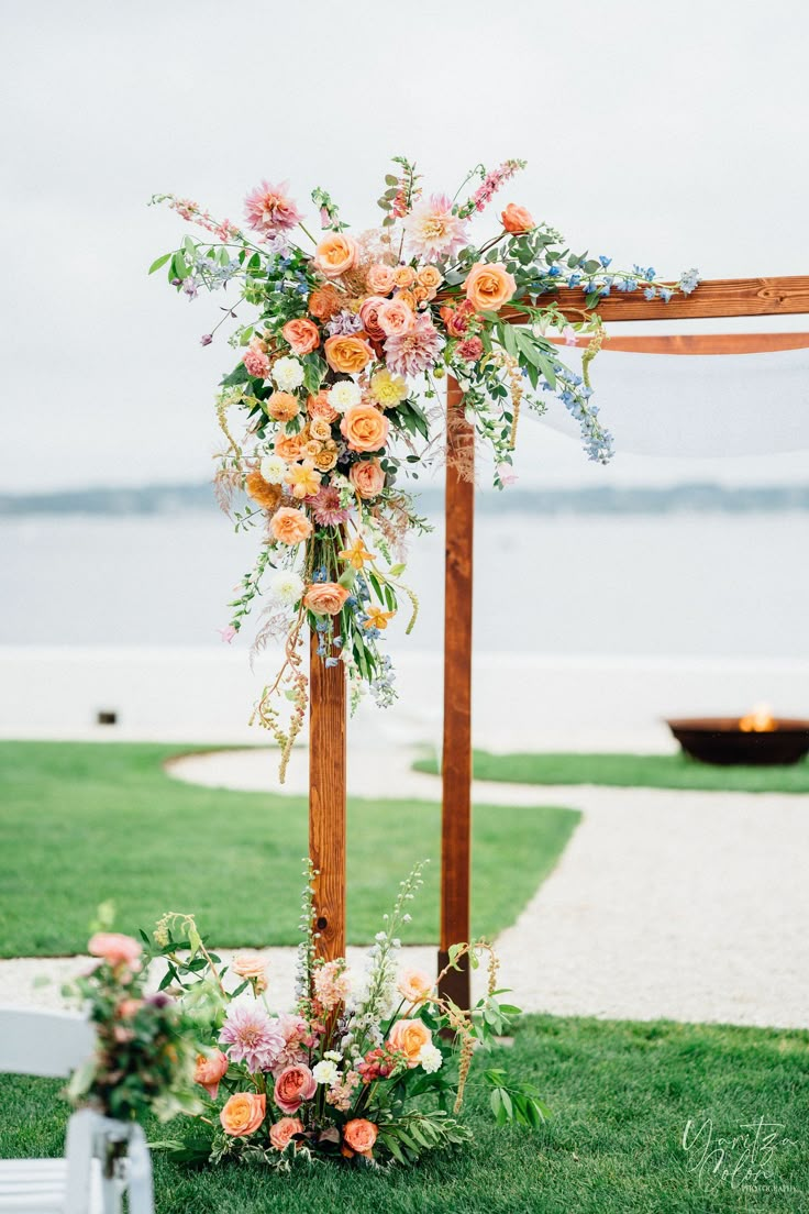 an outdoor ceremony setup with flowers and greenery