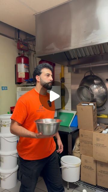 a man in an orange shirt is holding a bowl