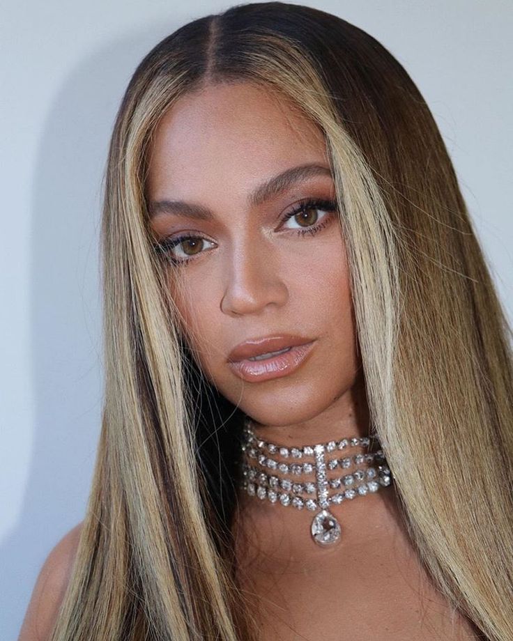 a woman with long blonde hair wearing a choker necklace and diamond jewelry on her neck