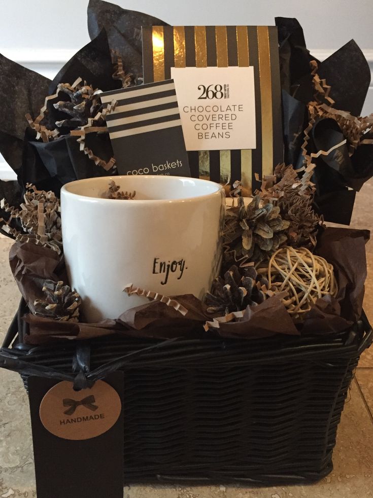 a coffee cup sitting on top of a basket filled with chocolates and other items