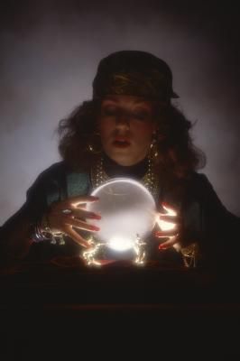 a woman holding a crystal ball in her hands and looking at the light coming from it