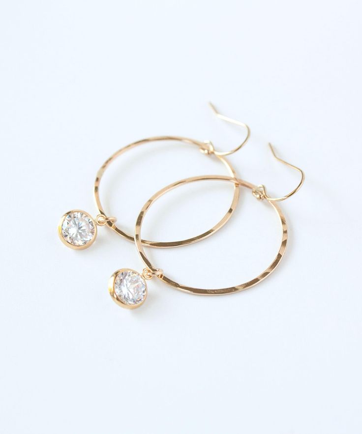 "Light catching CZ drops are suspended from hammered 14k Gold Filled hoops with our new Chloe Hoop Earrings. This classic design is perfect for daily wear, a night out or a wedding party. All gold elements, including CZ settings, are made from superior quality 14k Gold Filled and will endure for years to come. You may also like these styles from the Chloe Collection: CZ Huggie Hoops >> https://www.etsy.com/listing/1155443088 CZ threaders >> https://www.etsy.com/listing/770882053 MATERIALS: 14k G Gold-tone Clip-on Hoop Earrings For Gift, 14k Gold-filled Gold-tone Hoop Earrings, Hammered 14k Gold-filled Hoop Earrings, Rose Gold 14k Gold-filled Hoop Earrings, Gold Hoop Crystal Earrings Nickel-free, Gold Filled Hoops, Earrings Crystal, Vermeil Jewelry, Crystal Drop Earrings