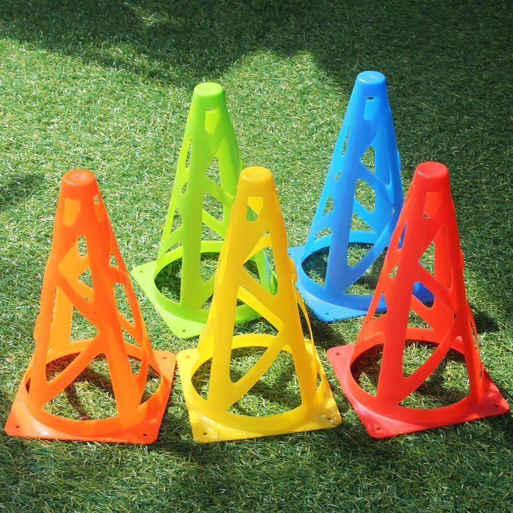 several plastic cones sitting in the grass