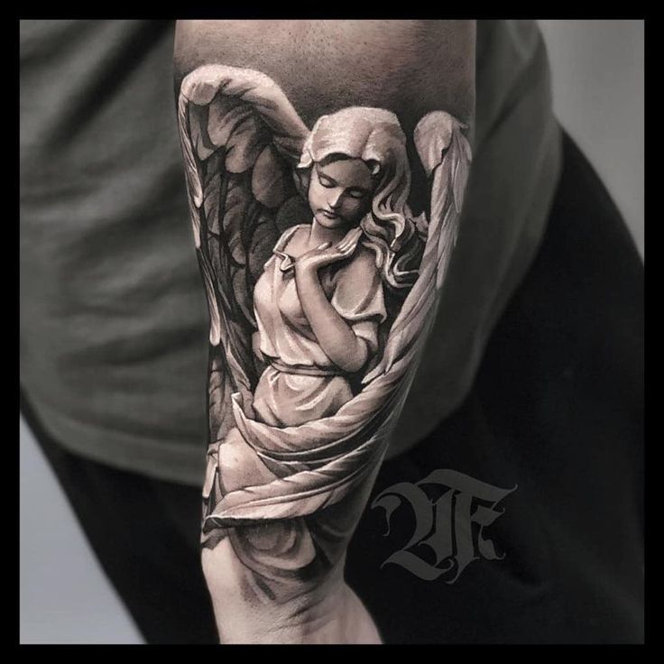 a man with a tattoo on his arm holding an angel