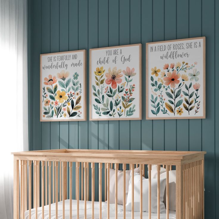 a baby's crib with three paintings on the wall