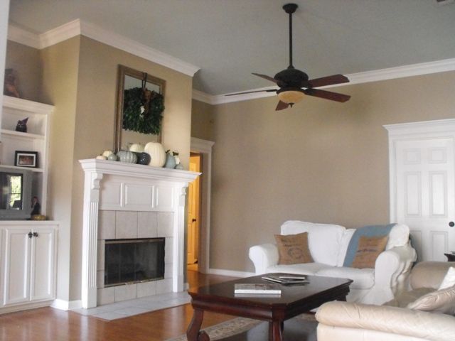 a living room filled with furniture and a fire place next to a white fireplace mantel