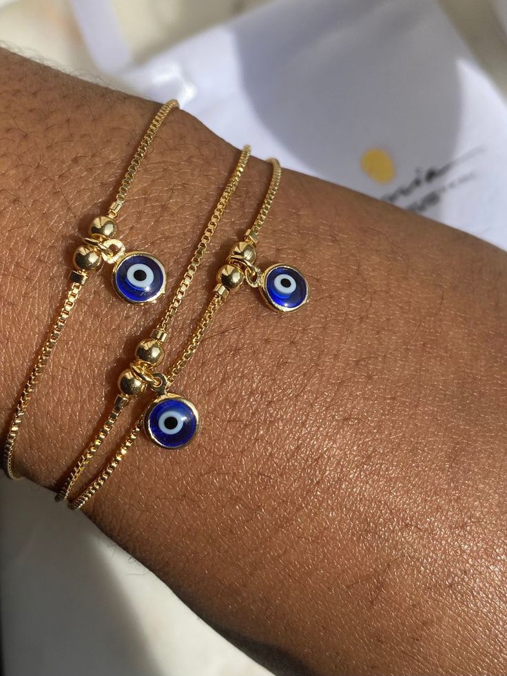 Gold Filled Evil Eye Bracelet Perfect as an accent bracelet or as a part of a stack with your other bracelets. 1mm dainty box Chain  6.5mm Evil Eye charm  The evil eye bracelet is adjustable while the herringbone bracelet has a lobster claw. Both are made from 18K Gold Filled Brazilian Gold. If you would like to purchase the herringbone alone, use the link below. https://www.etsy.com/uk/listing/914777068/18k-gold-filled-herringbone-bracelet? If you have any questions, please send me a message an Evil Eye Bracelet Gold, Herringbone Bracelet, Brazilian Gold, Turkish Eye, Gold Armband, Jewelry Accessories Ideas, Jewelry Lookbook, Eye Bracelet, Gold Bracelet Chain