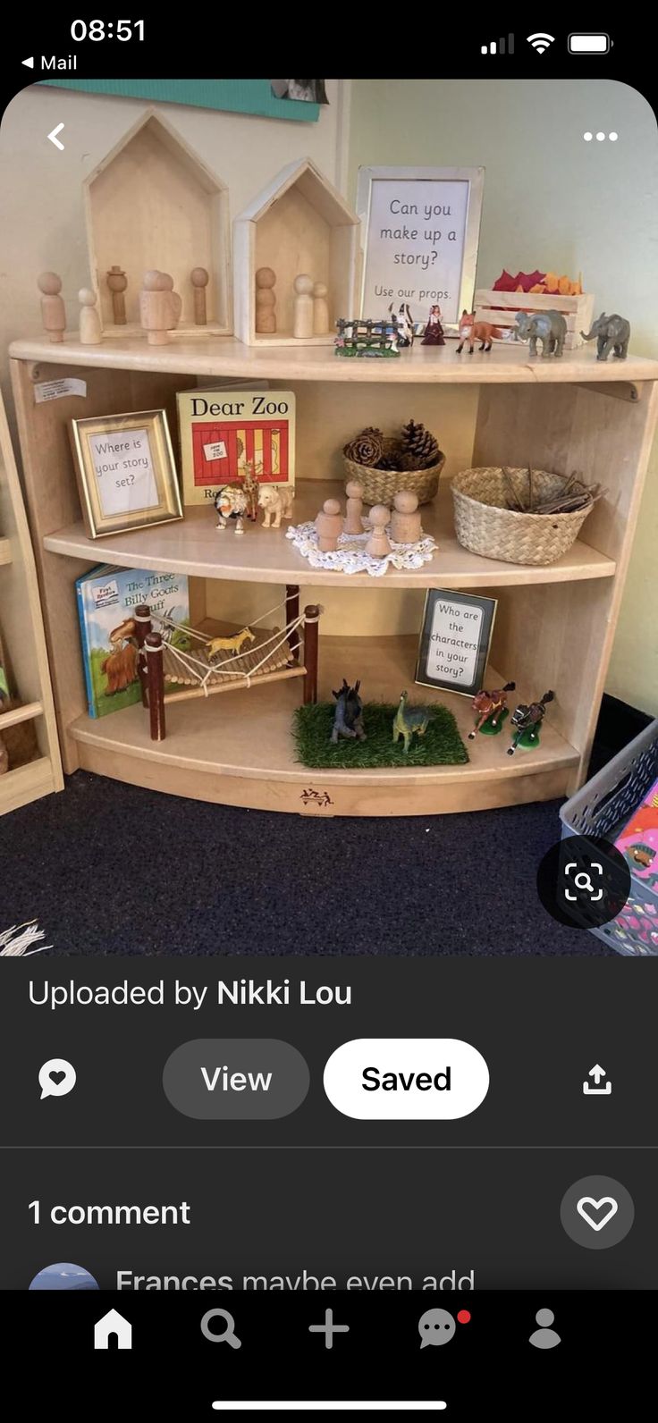 an image of a shelf with books and toys on it in the middle of a room