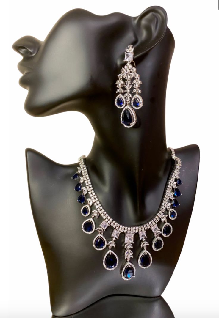 Add some sparkle to any occasion with our CZ American Diamond Necklace. Perfect for weddings, parties, or as a gift for her. This stunning necklace, made with beautiful bluestones, will elevate any outfit like sarees, gowns, or lehengas. Make a statement with this beautiful and versatile piece. This jewellery set includes a necklace and matching earrings. Jewellery Care- Keep the jewellery dry, avoid contact with perfumes and water. American Diamond Necklaces, Bridal Choker, Jewellery Set, American Diamond, Stunning Necklace, Bridal Sets, Matching Earrings, Jewelry Care, Jewelry Set