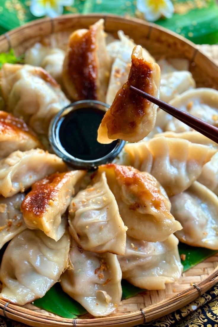 a basket filled with dumplings covered in sauce