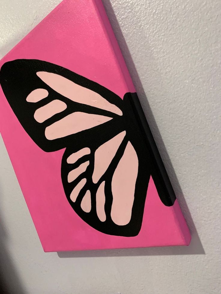 a pink and black butterfly painted on a wall