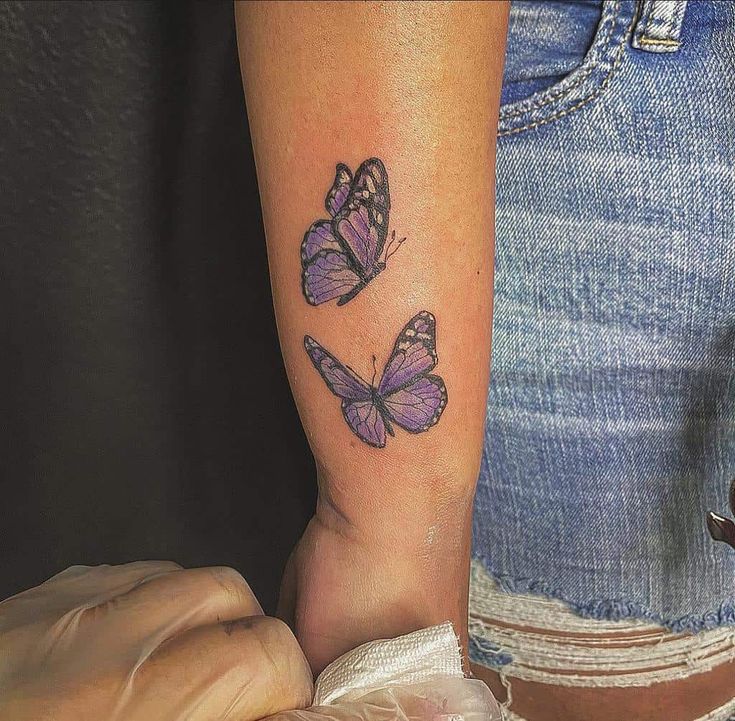 two purple butterflies on the right arm and one is in the middle of the leg