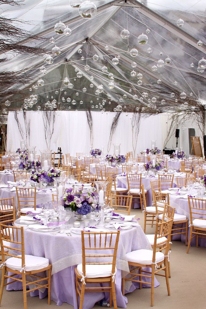 the tables are set with white linens and purple centerpieces for an elegant wedding reception