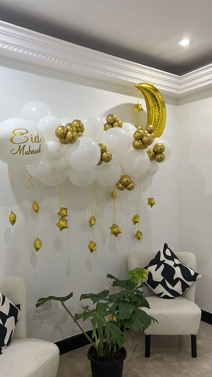 balloons are hanging from the ceiling in front of a wall with gold stars and crescents