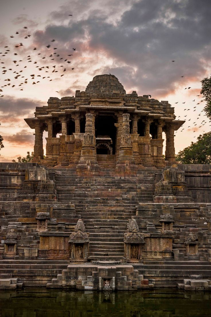 an ancient temple with birds flying in the sky above it and text that reads, modhera sun temple