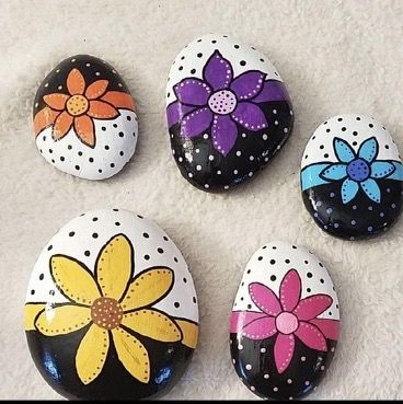 four painted rocks with flowers on them