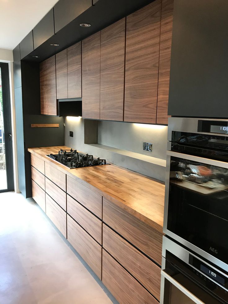 a modern kitchen with wooden cabinets and stainless steel appliances, including an electric stove top oven