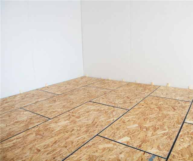 an unfinished room with wood flooring in the middle and white walls on the other side