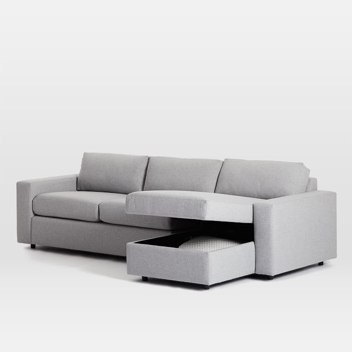 a couch with a footstool sitting next to it on top of a white floor