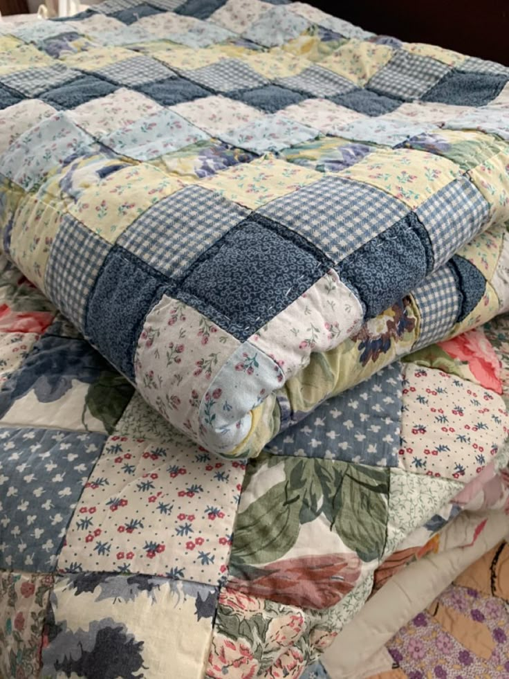 a quilted bed with blue and white flowers on it