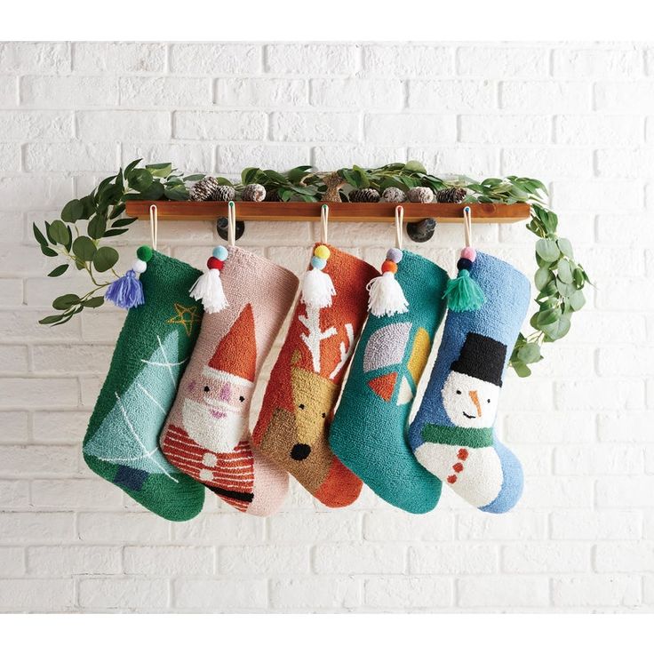 christmas stockings hanging from a wooden rack on a brick wall