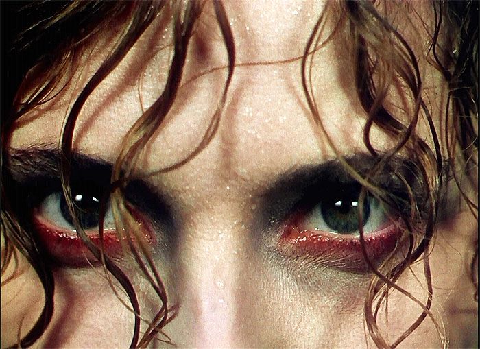 a close up of a person with long hair and red eyeliners on their eyes