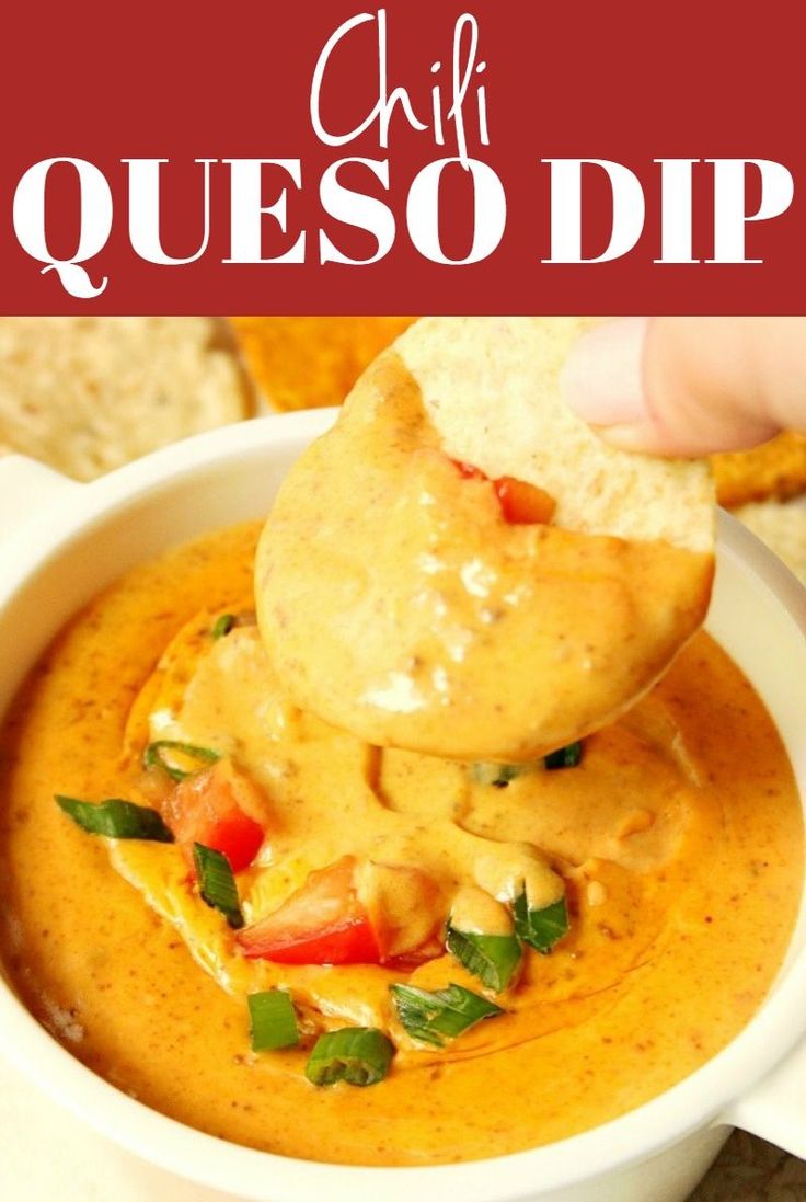 a hand dipping tortilla chips into a bowl of queso dip