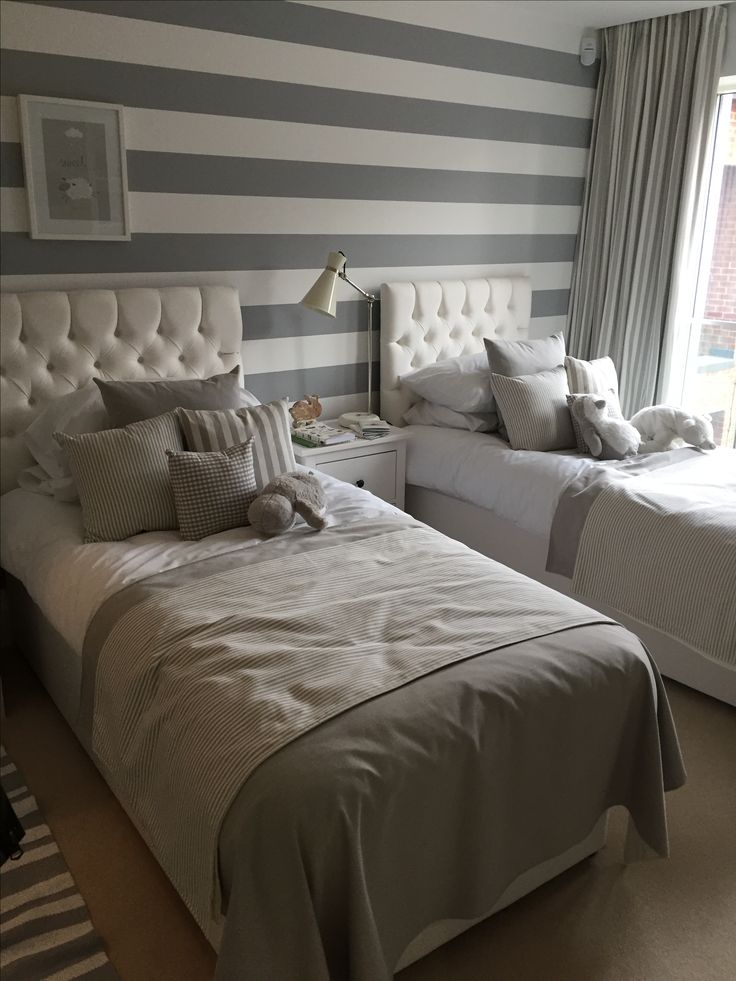 two twin beds in a bedroom with striped walls