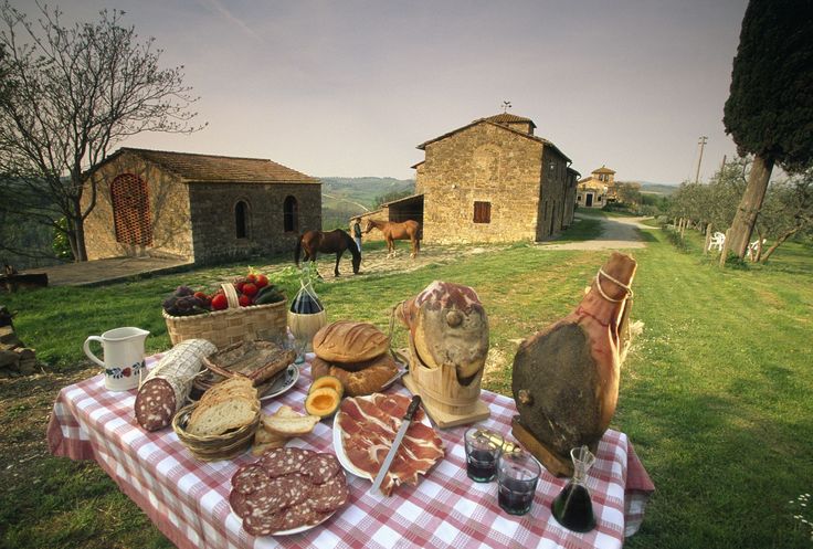 a picnic table with bread, meats and wine on it