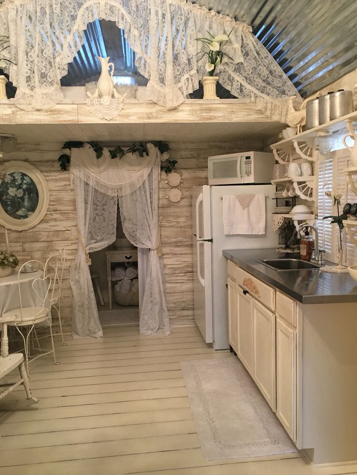 a kitchen with white appliances and curtains on the windows over the stove top ovens