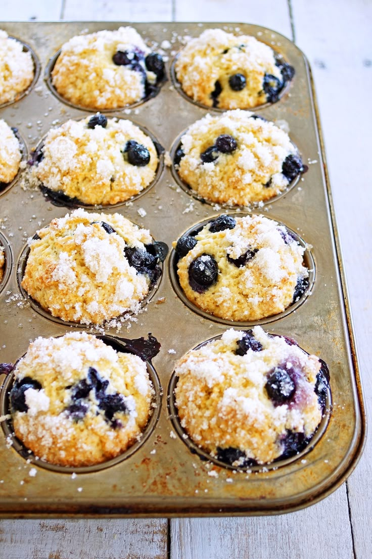 a muffin tin filled with blueberry crumbs