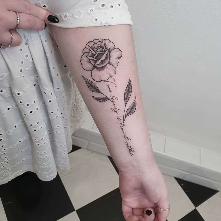 a woman with a rose tattoo on her arm