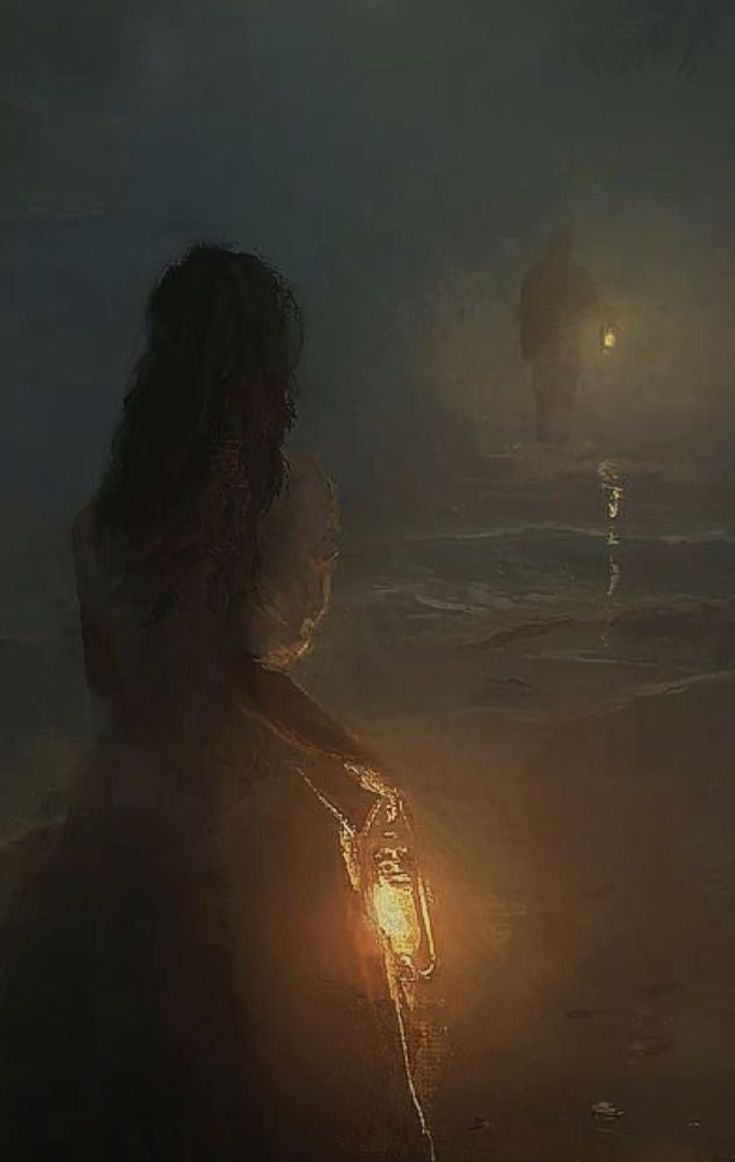 a person standing in the water with a light on their hand and two people walking behind them