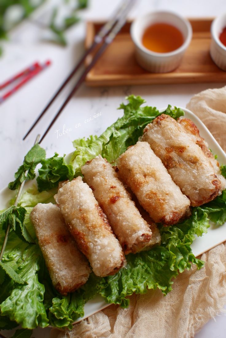 some food that is on a plate with chopsticks and sauce in the background