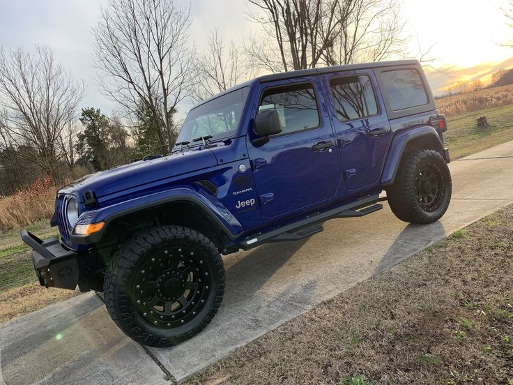 a blue jeep parked on the side of a road