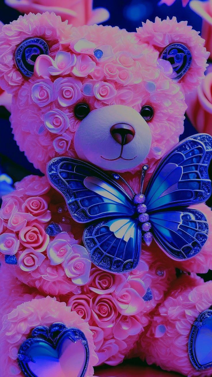 a pink teddy bear with a blue butterfly on it's chest sitting in front of roses