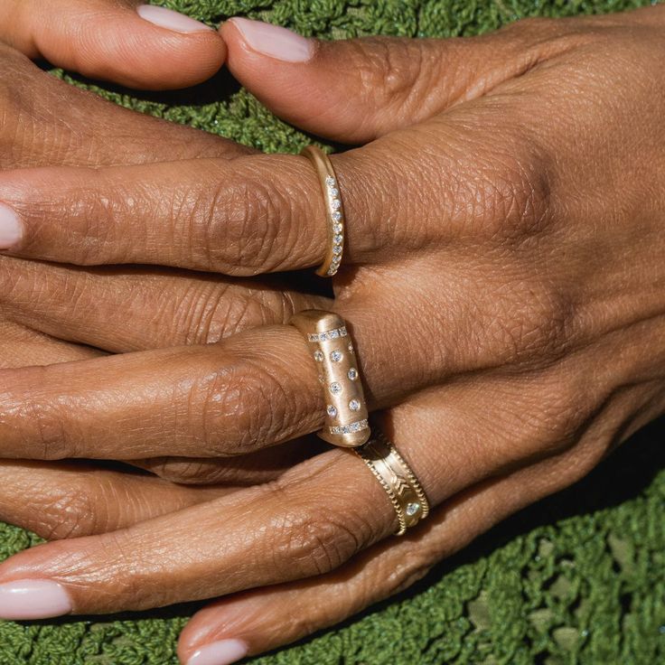 two hands holding each other with wedding rings on their fingers and pearls in the middle