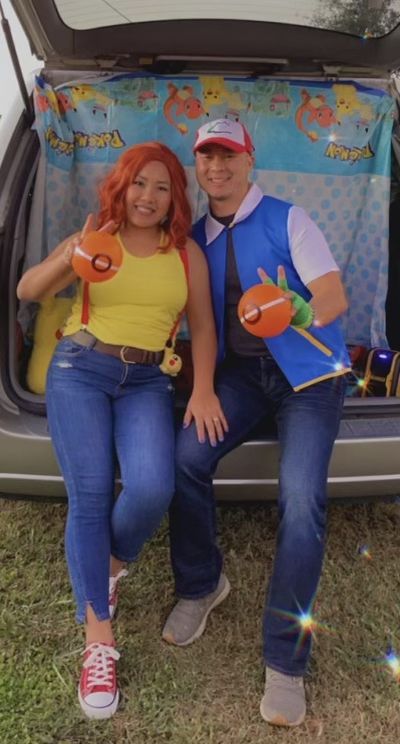 a man and woman sitting in the trunk of a car