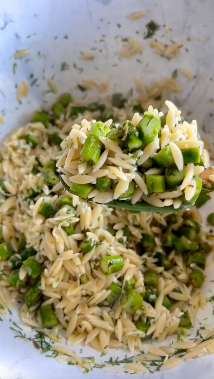 a spoon full of pasta and peas with parmesan cheese